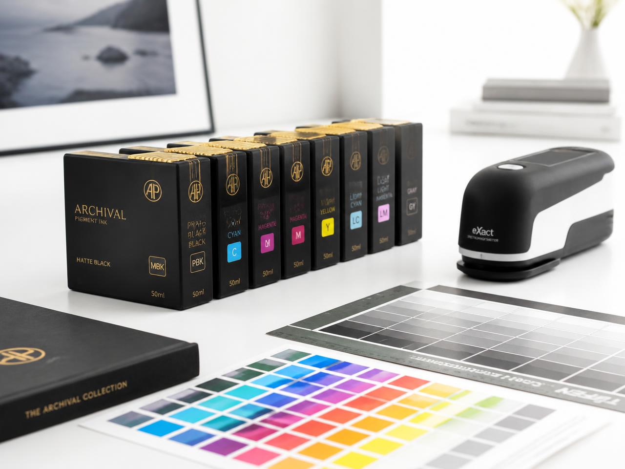 Archival pigment ink cartridges beside colour calibration charts and a spectrophotometer